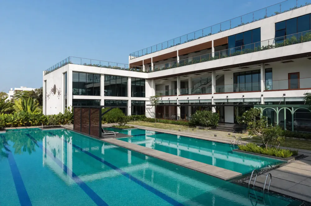 Clubhouse lap pool beside a three-storey glass building